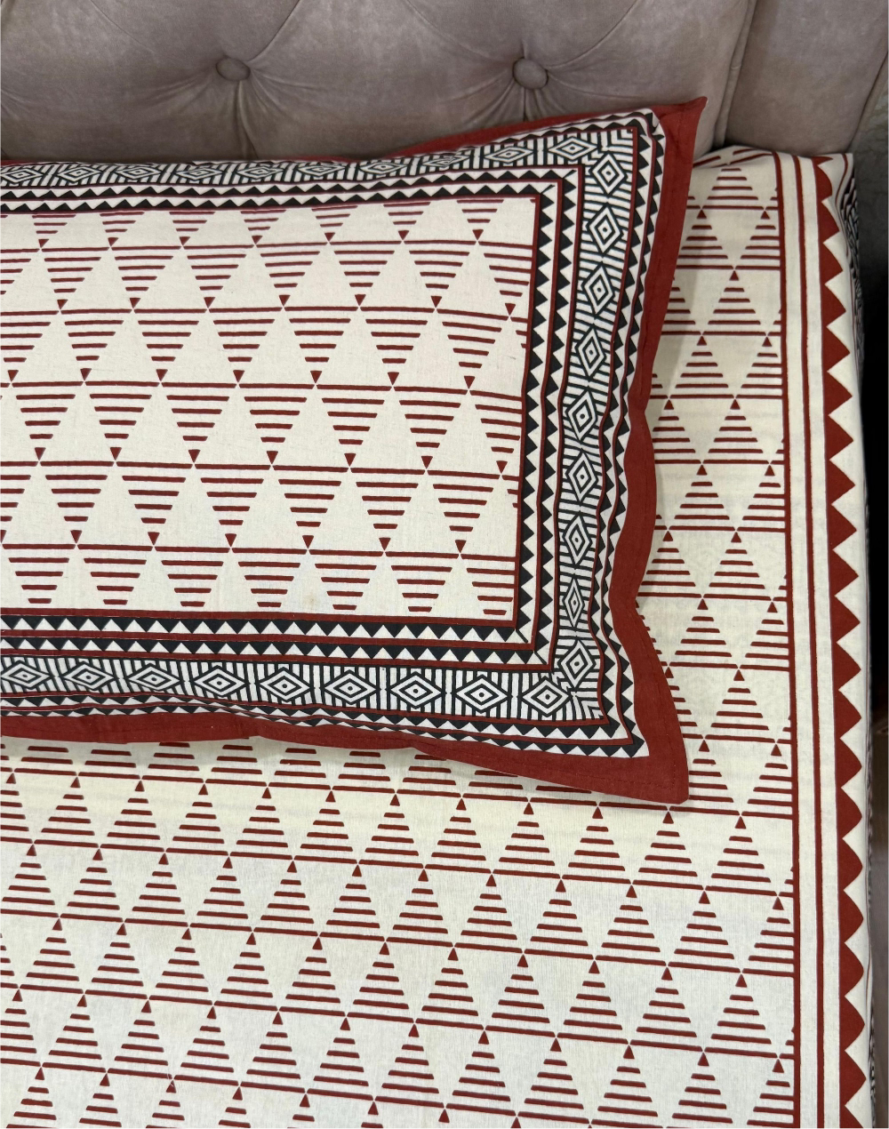 Patterned bedspread with geometric design on a bed