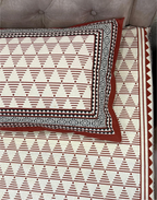 Patterned bedspread with geometric design on a bed
